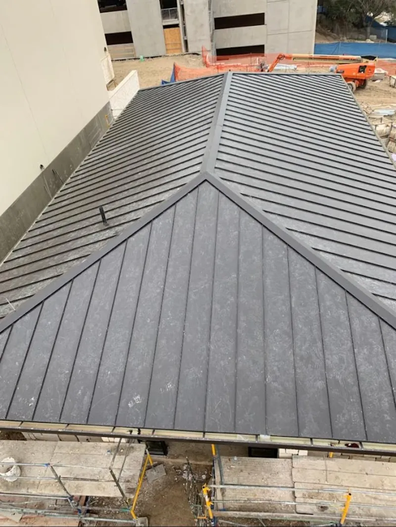 Commercial metal roof construction with crane equipment in Winchester